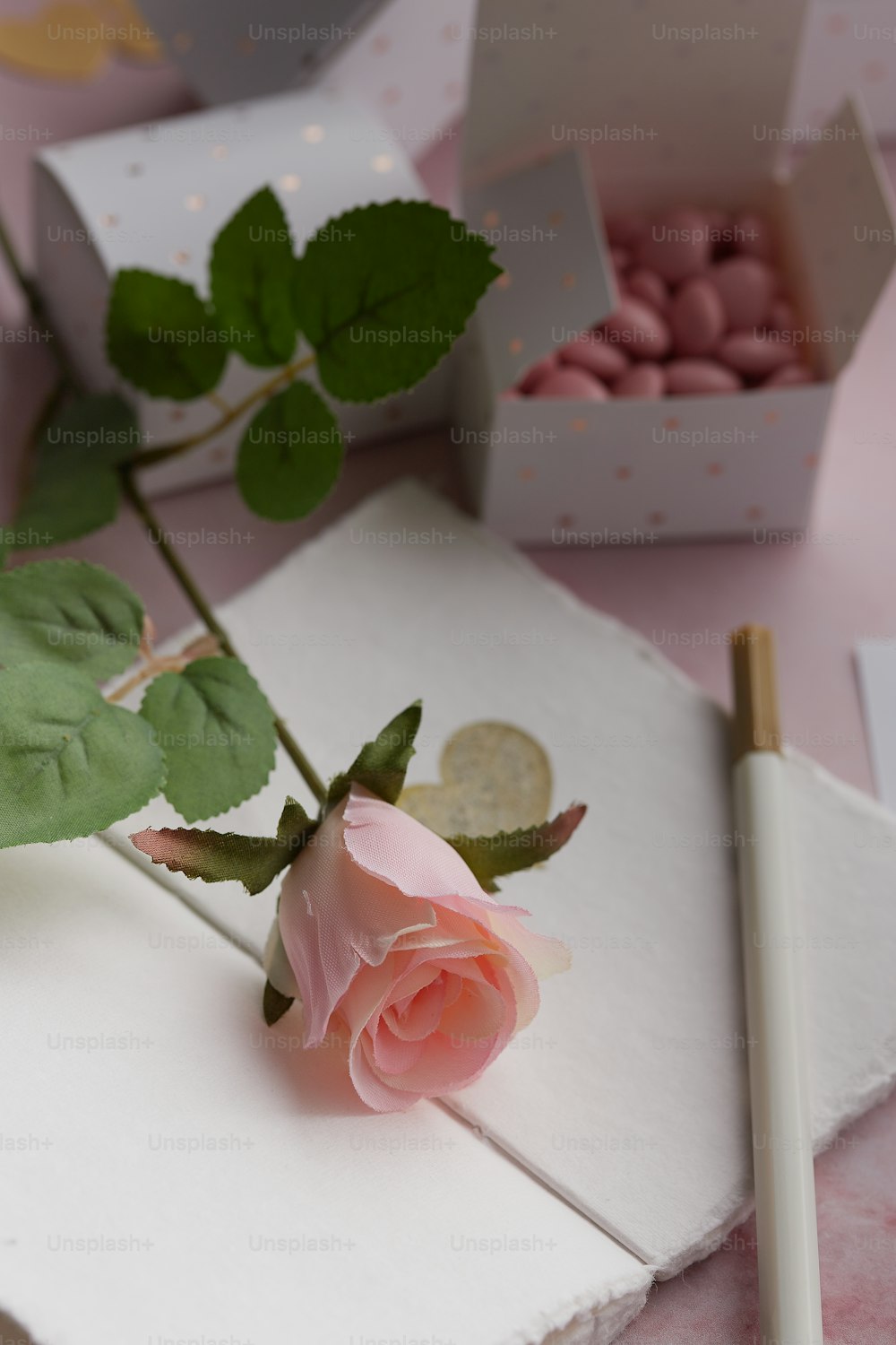 a pink rose sitting on top of a white table