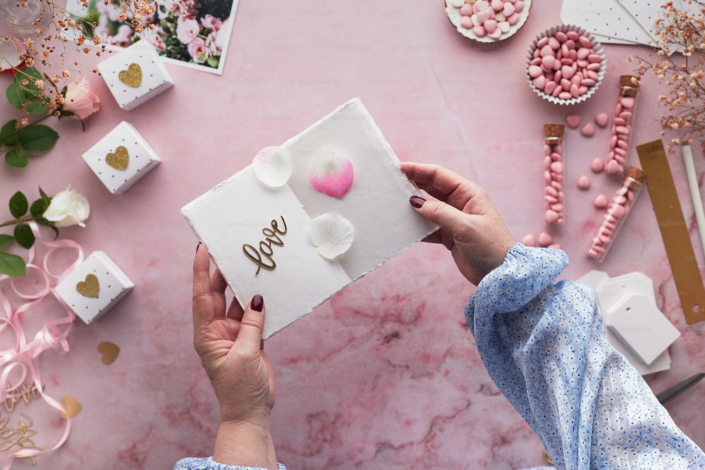 a person holding a card with a heart on it