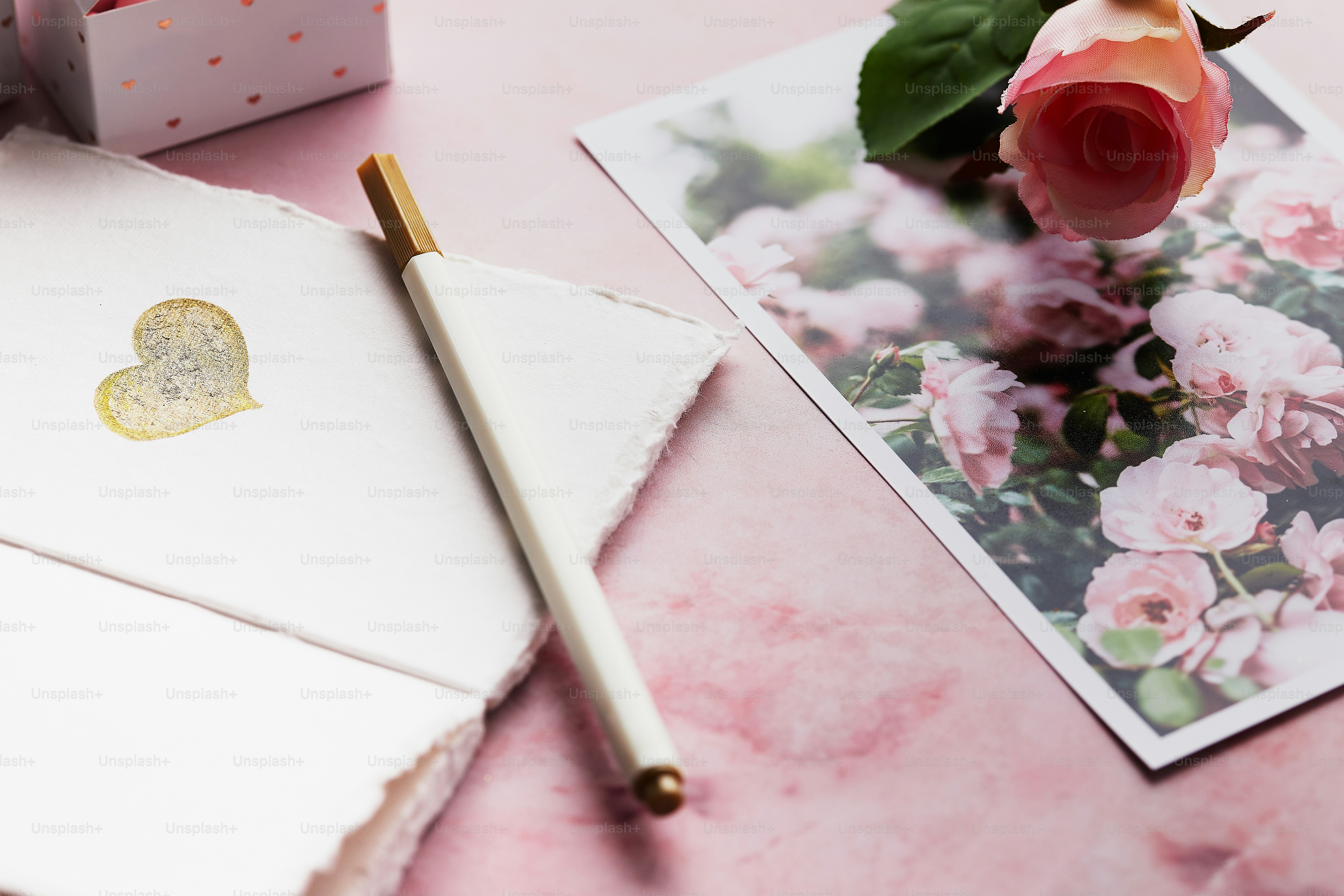 a notepad with a heart on it next to a flower
