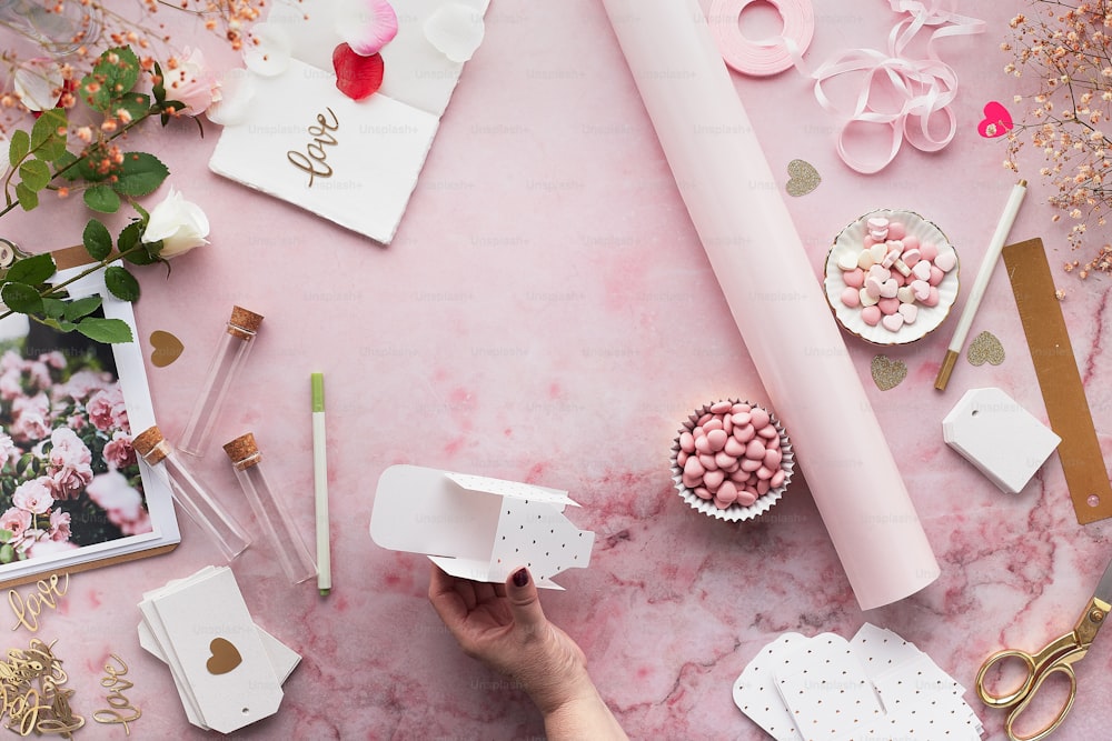 a pink table topped with lots of different items