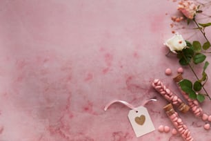 a pink marble table with pink beads and a white rose