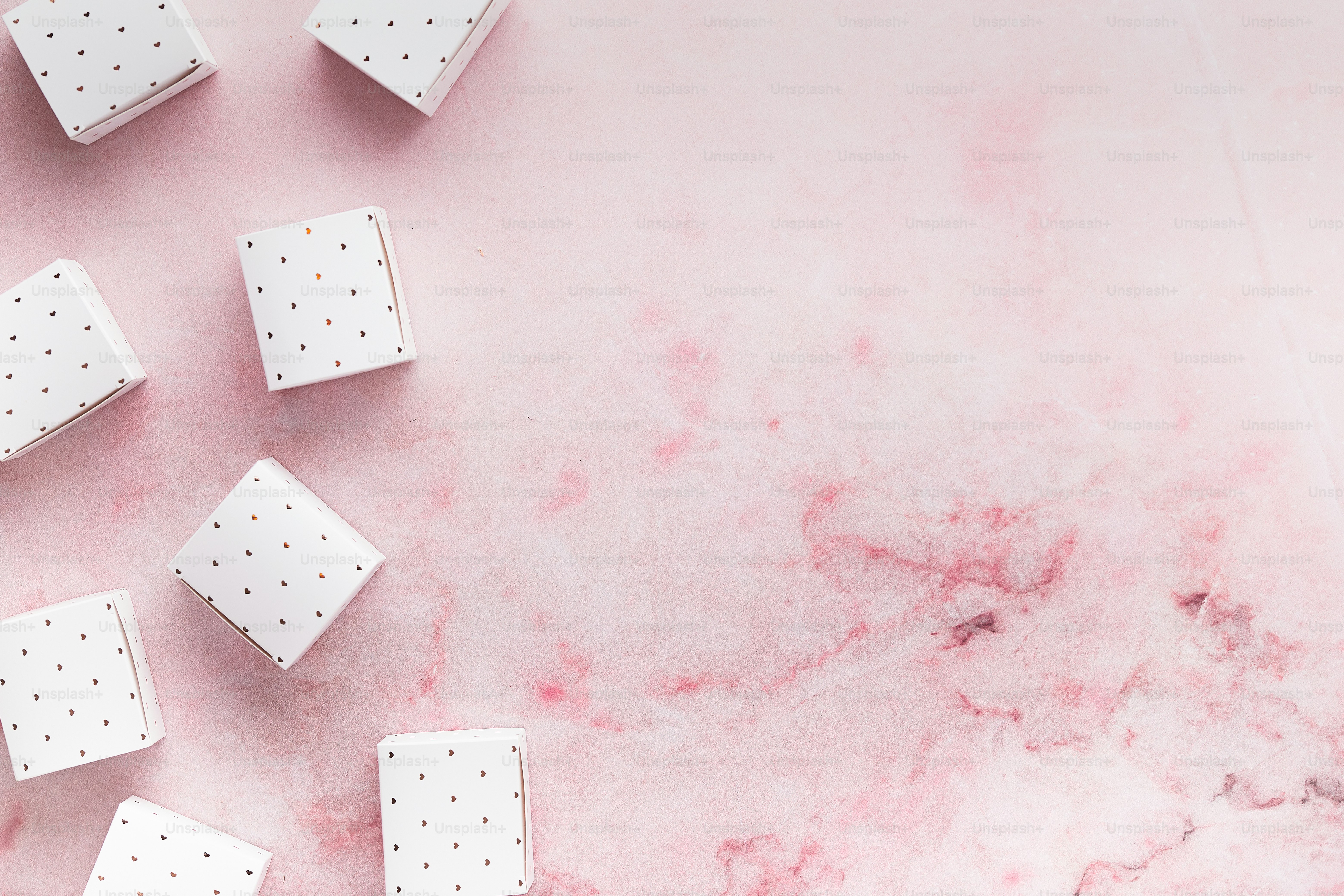 Eine Gruppe weißer Würfel sitzt auf einem rosa Tisch