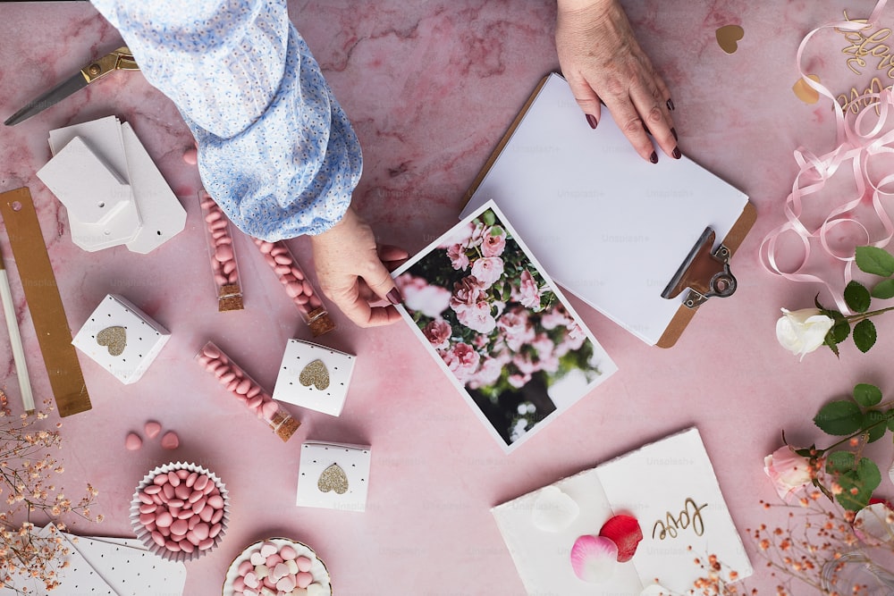 Una persona sosteniendo una imagen de una flor en una mesa