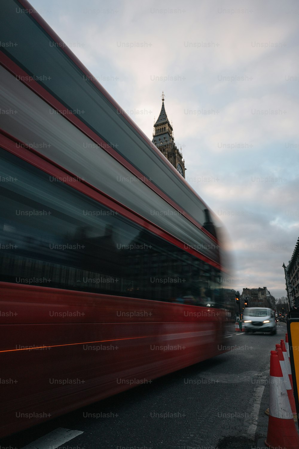 a red double decker bus driving down a street