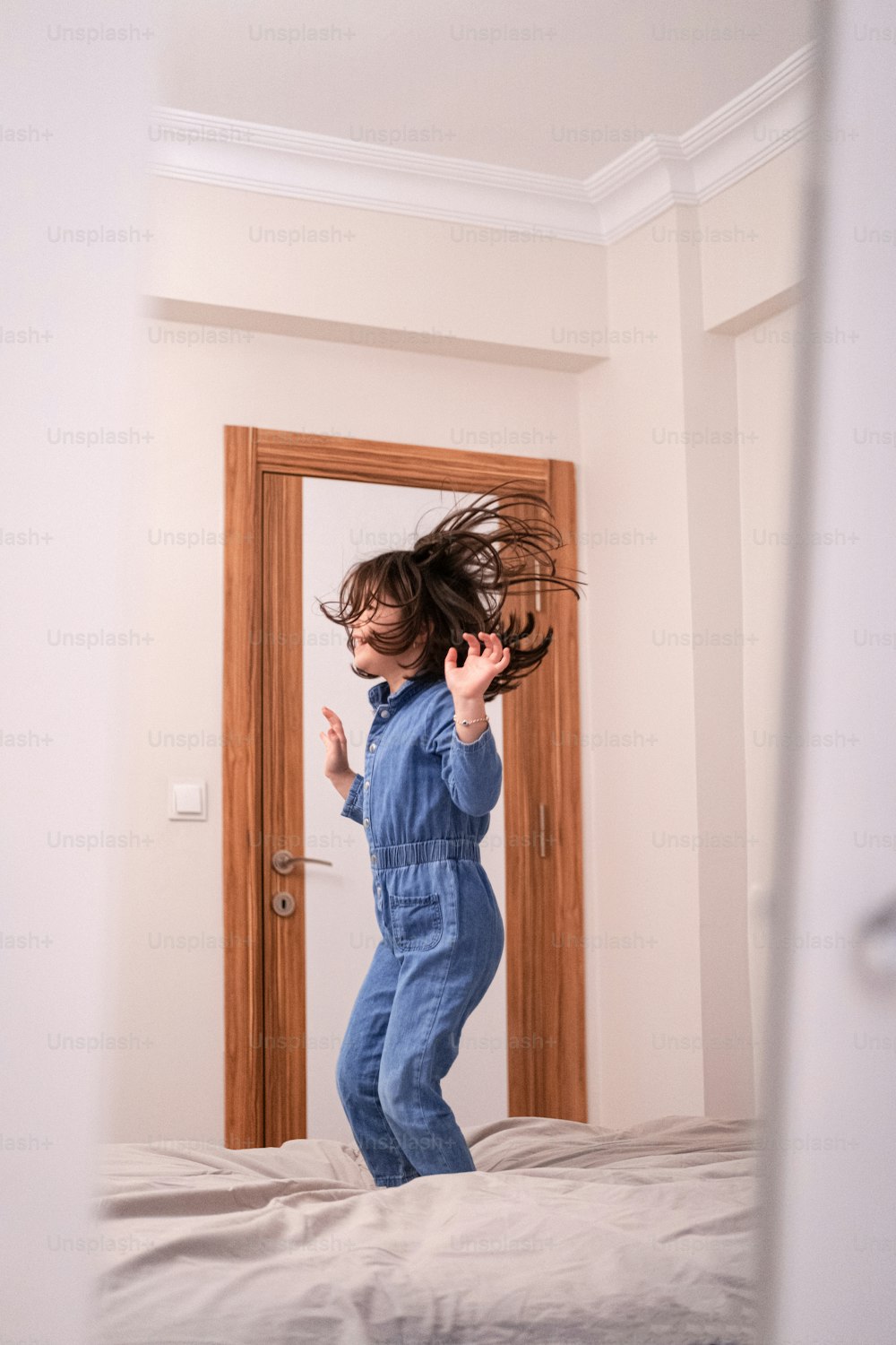 a young child jumping on a bed in a room