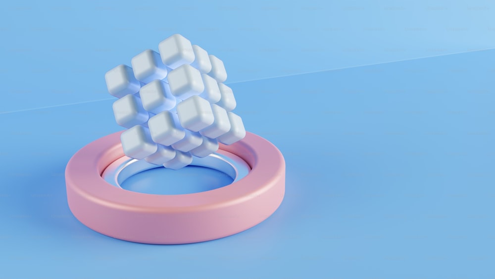 un anneau rose avec un cube blanc sur le dessus