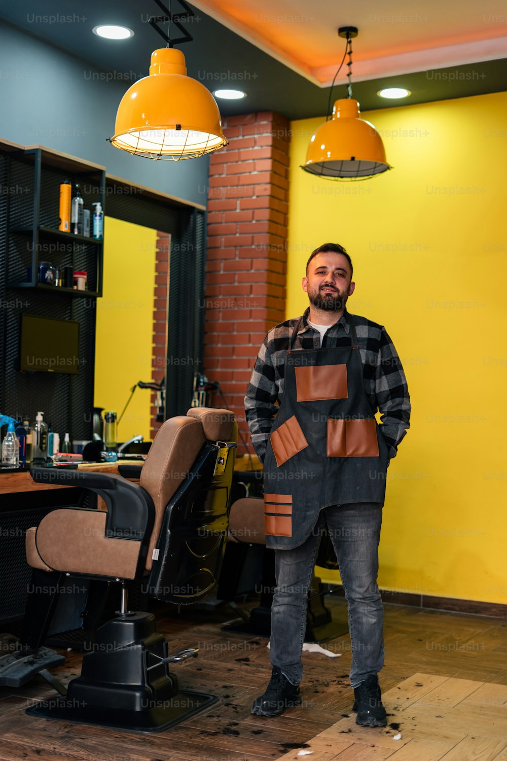 a man standing in a barbershop with his hands in his pockets