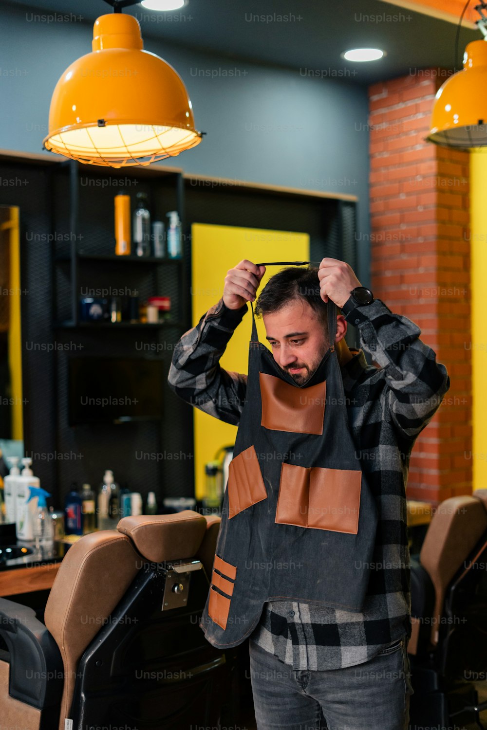 a man standing in a barber shop holding his hair
