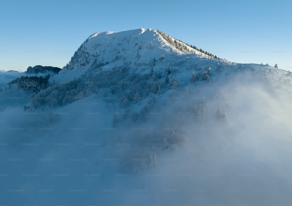 Ein schneebedeckter und von Wolken umgebener Berg