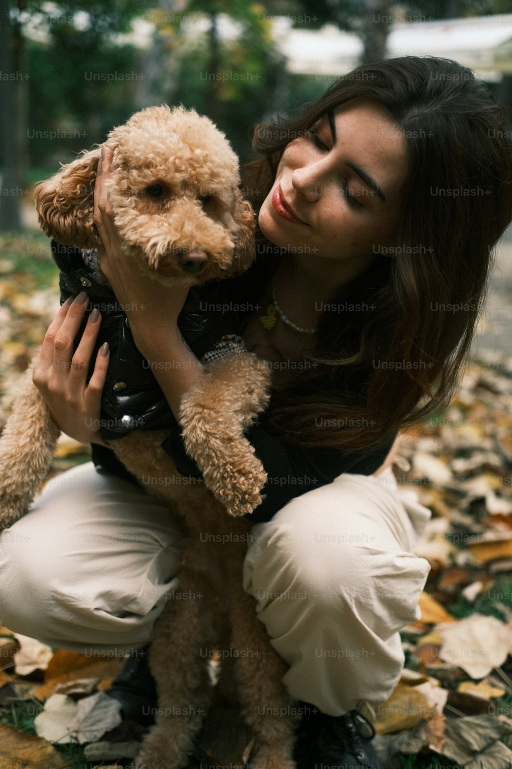 a woman is holding a dog in her arms