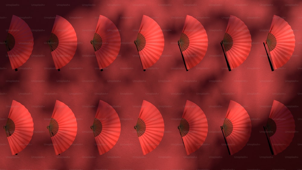 a bunch of red umbrellas that are on a wall