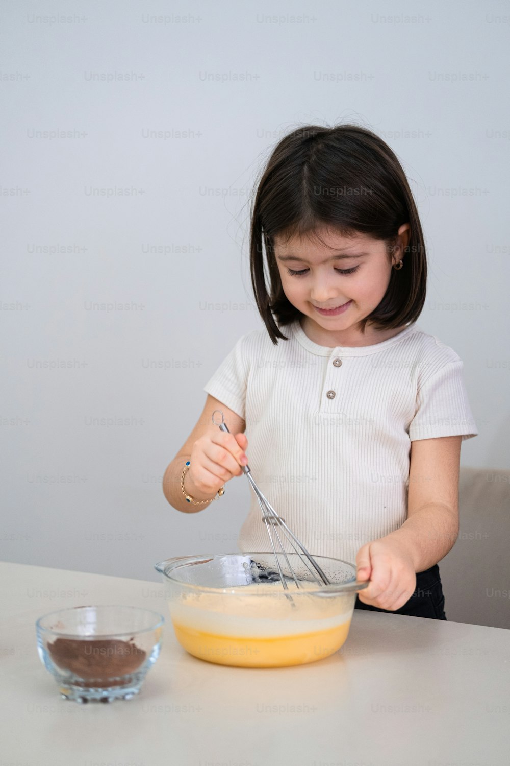 a little girl mixing something in a bowl