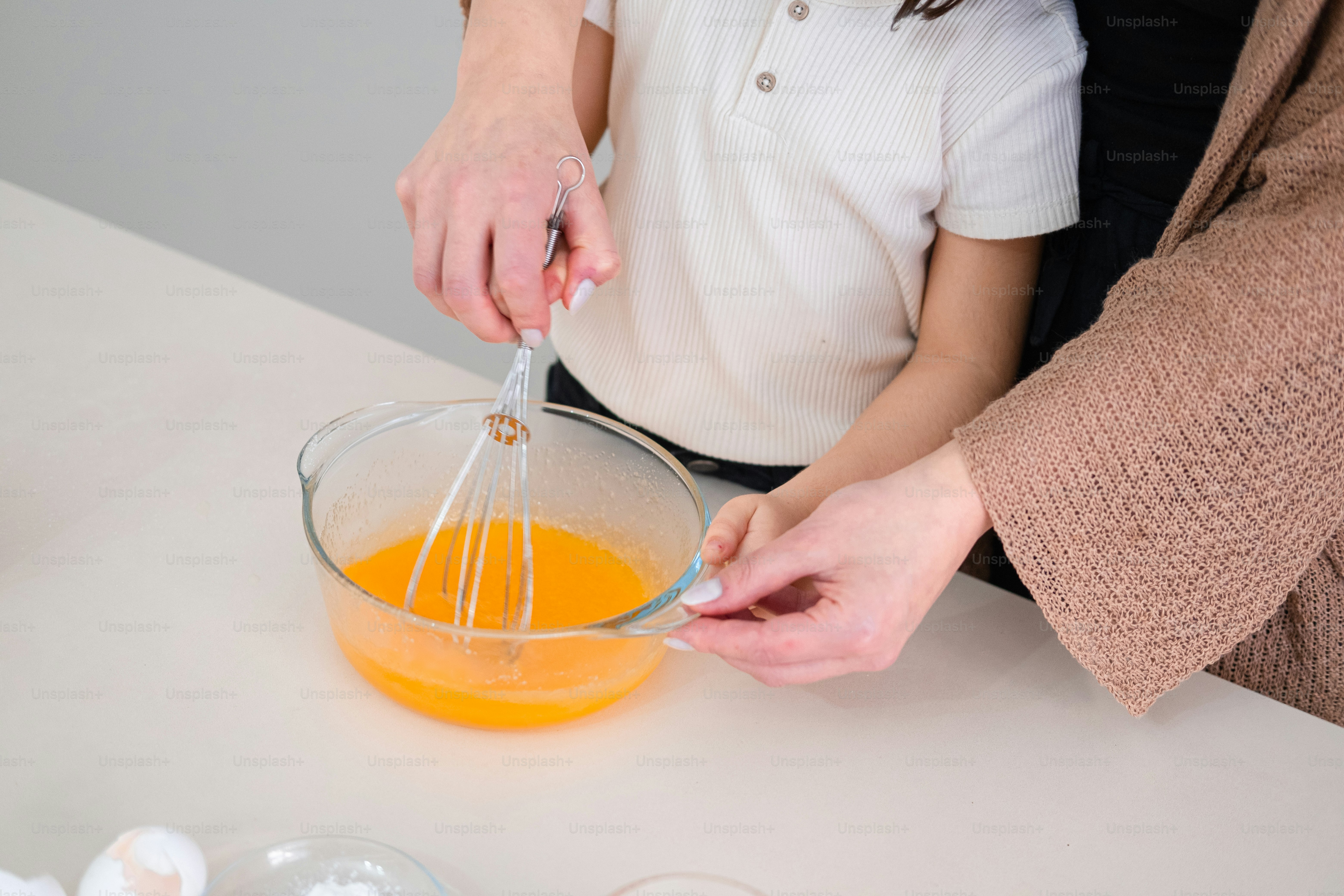 A couple of people that are mixing something in a bowl photo – Woman ...