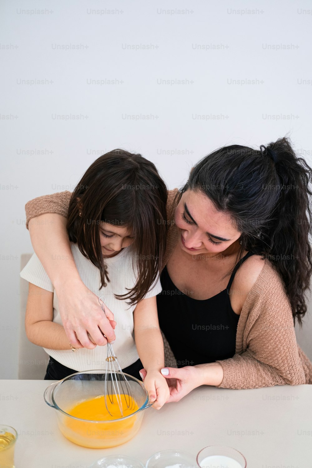 a mother and daughter mixing together a mixture