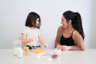 a woman and a little girl sitting at a table