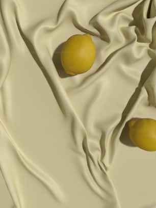 two lemons sitting on a white cloth