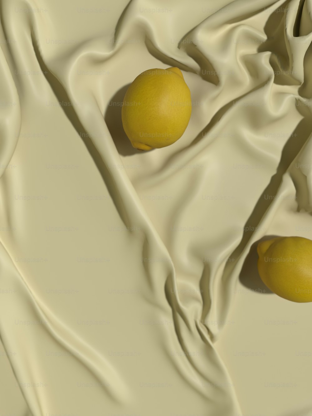 two lemons sitting on a white cloth