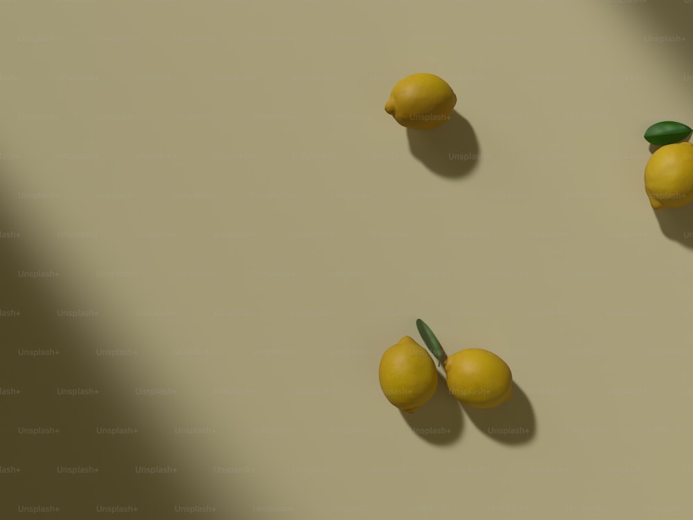 three lemons and two green leaves on a white surface