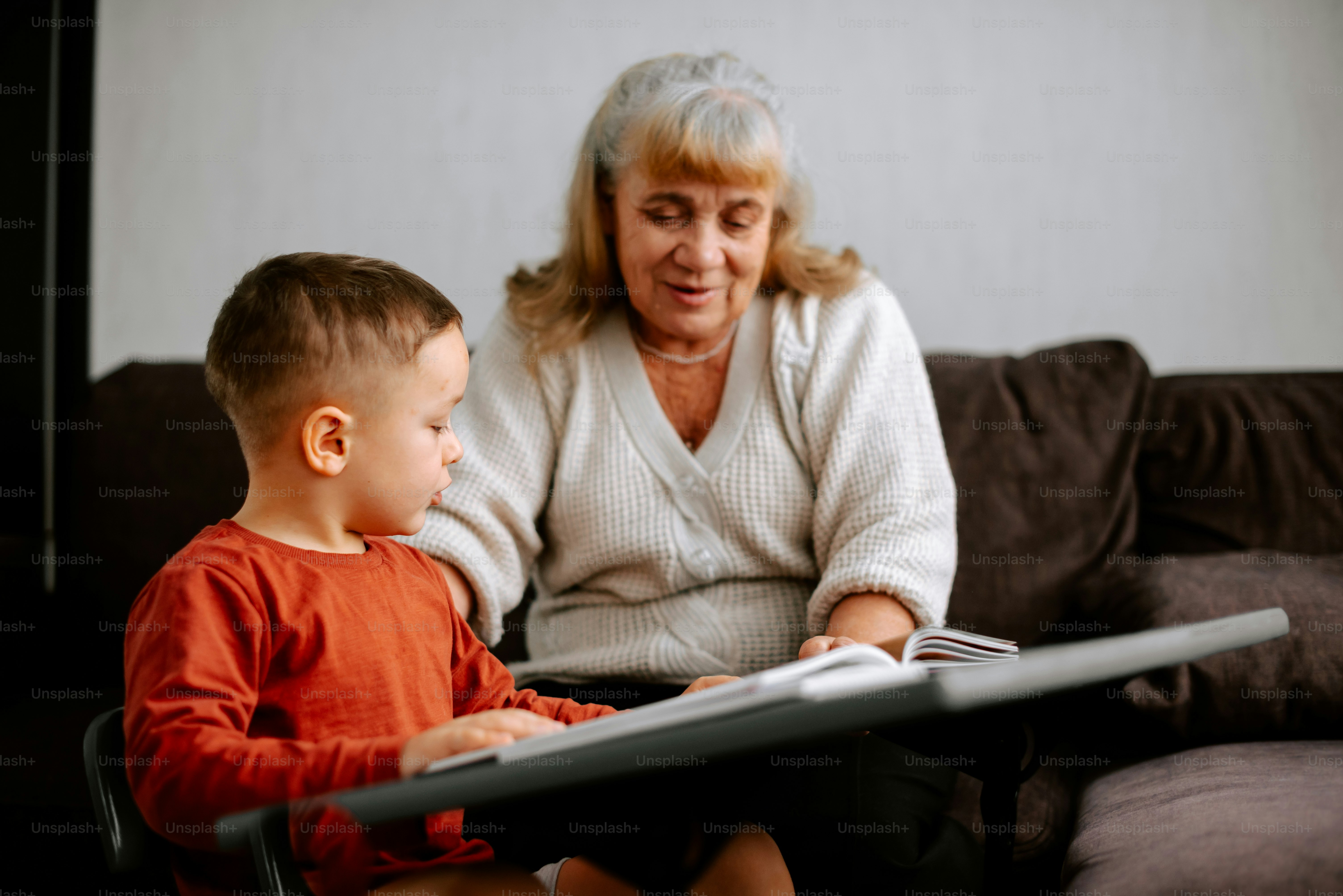 a woman sitting next to a boy on a couch