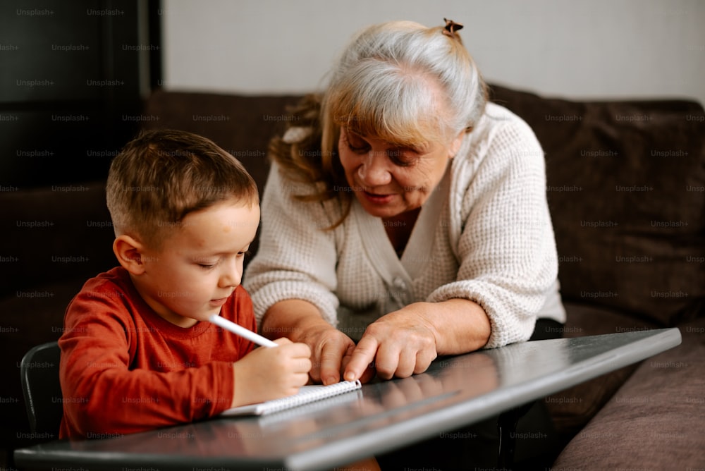 テーブルに座っている年配の女�性と若い男の子