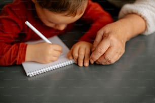 a little boy writing on a piece of paper