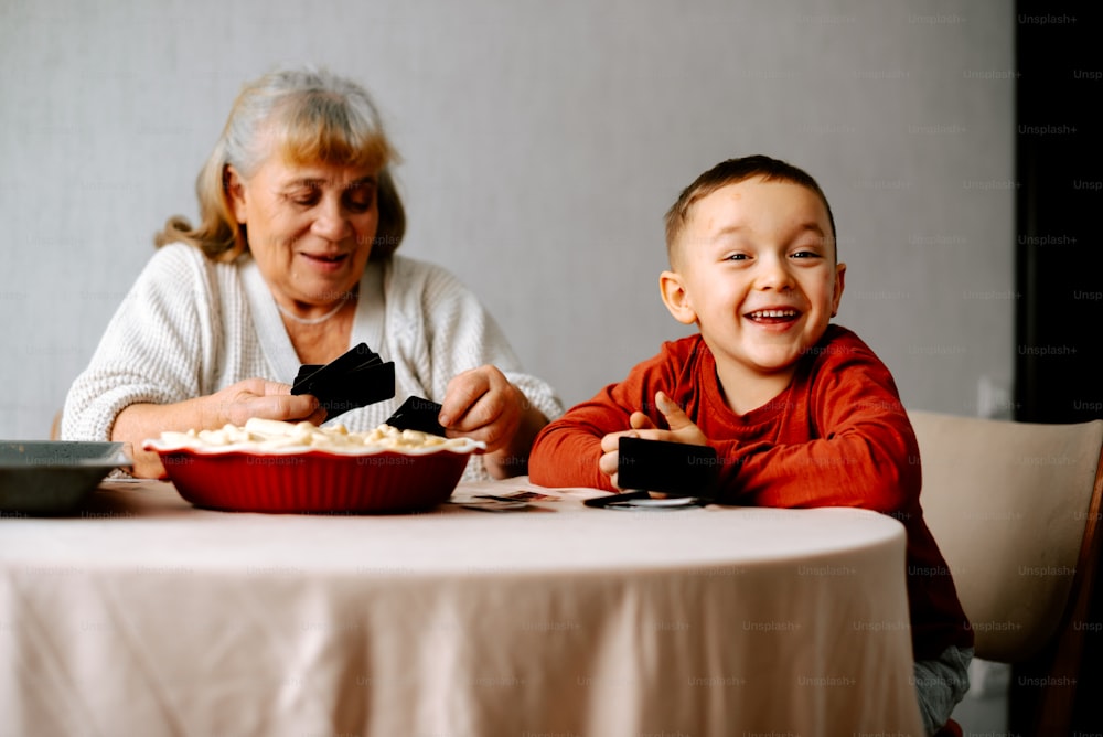 음식 한 그릇이 있는 테이블에 앉아 있는 여자와 아이