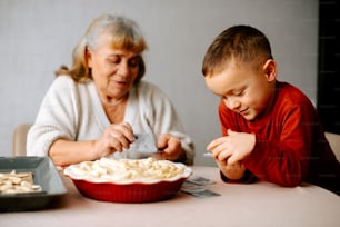 Eine Frau und ein Junge sitzen an einem Tisch mit Essen