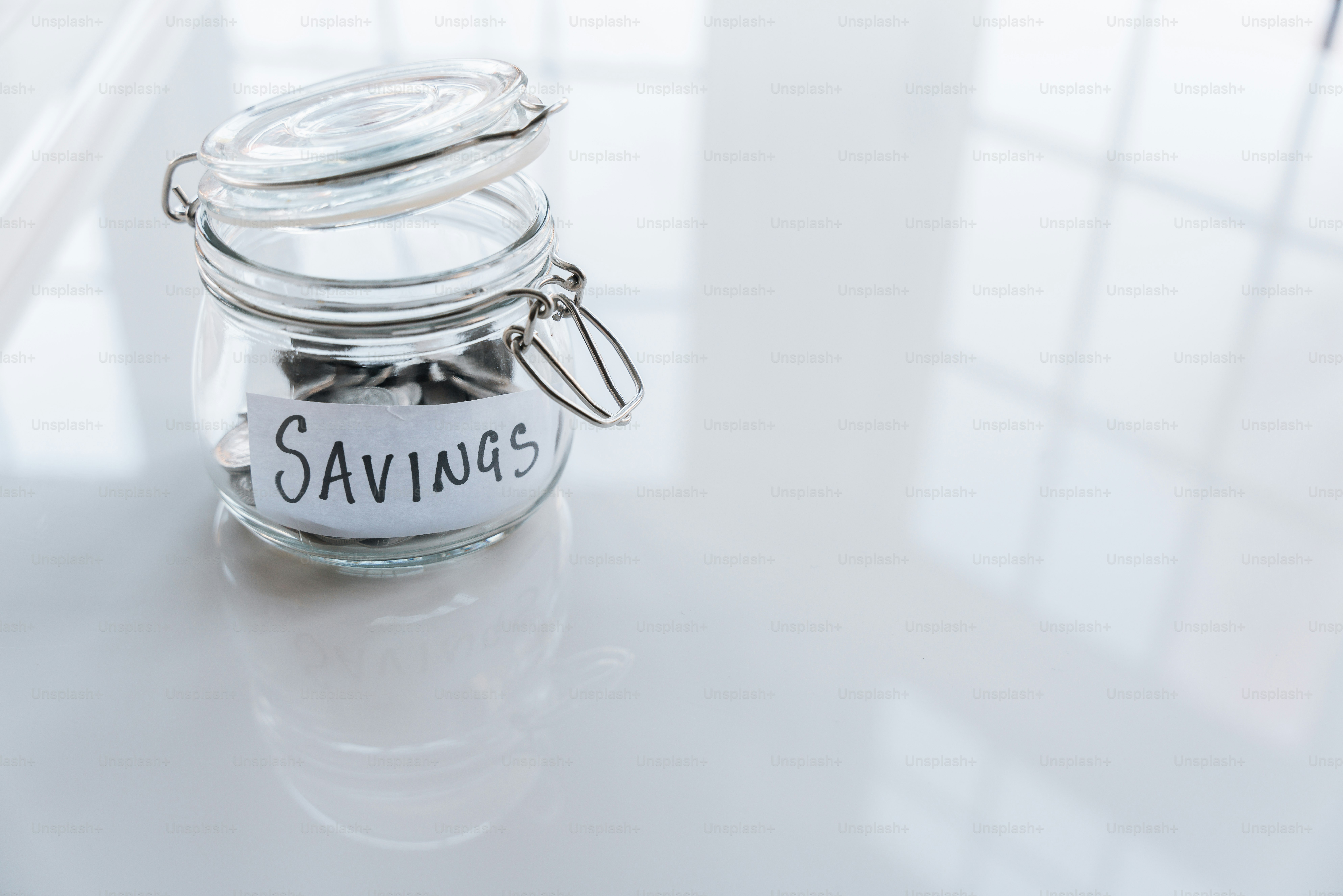 a glass jar filled with coins sitting on top of a table