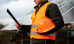 a man in a safety vest holding a piece of metal