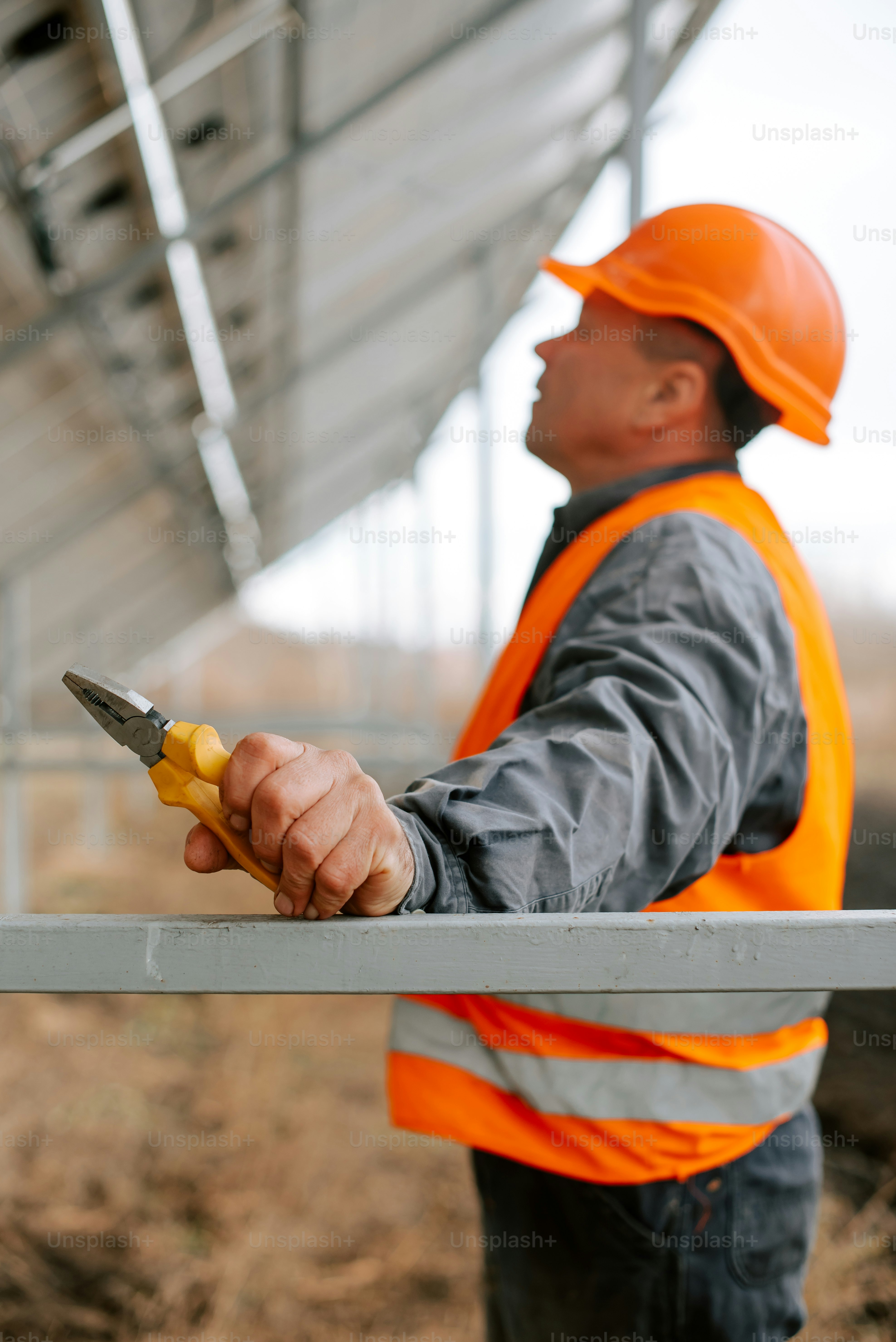 Ein Mann in einer orangefarbenen Warnweste mit einer Schere