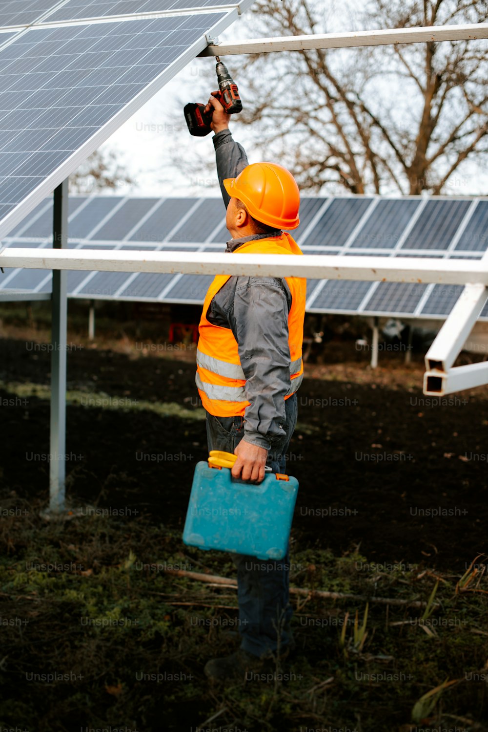 a man in a hard hat holding a blue briefcase