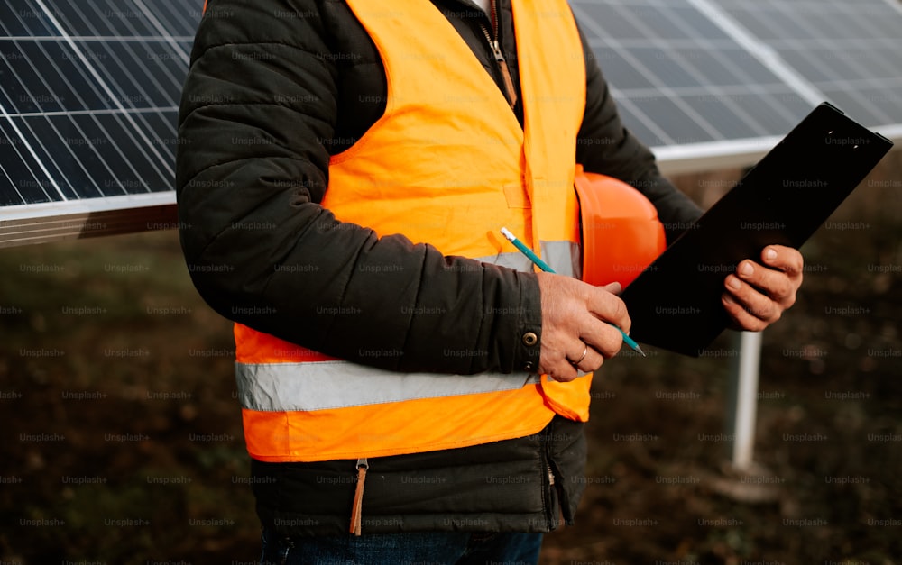 a man in an orange vest holding a clipboard