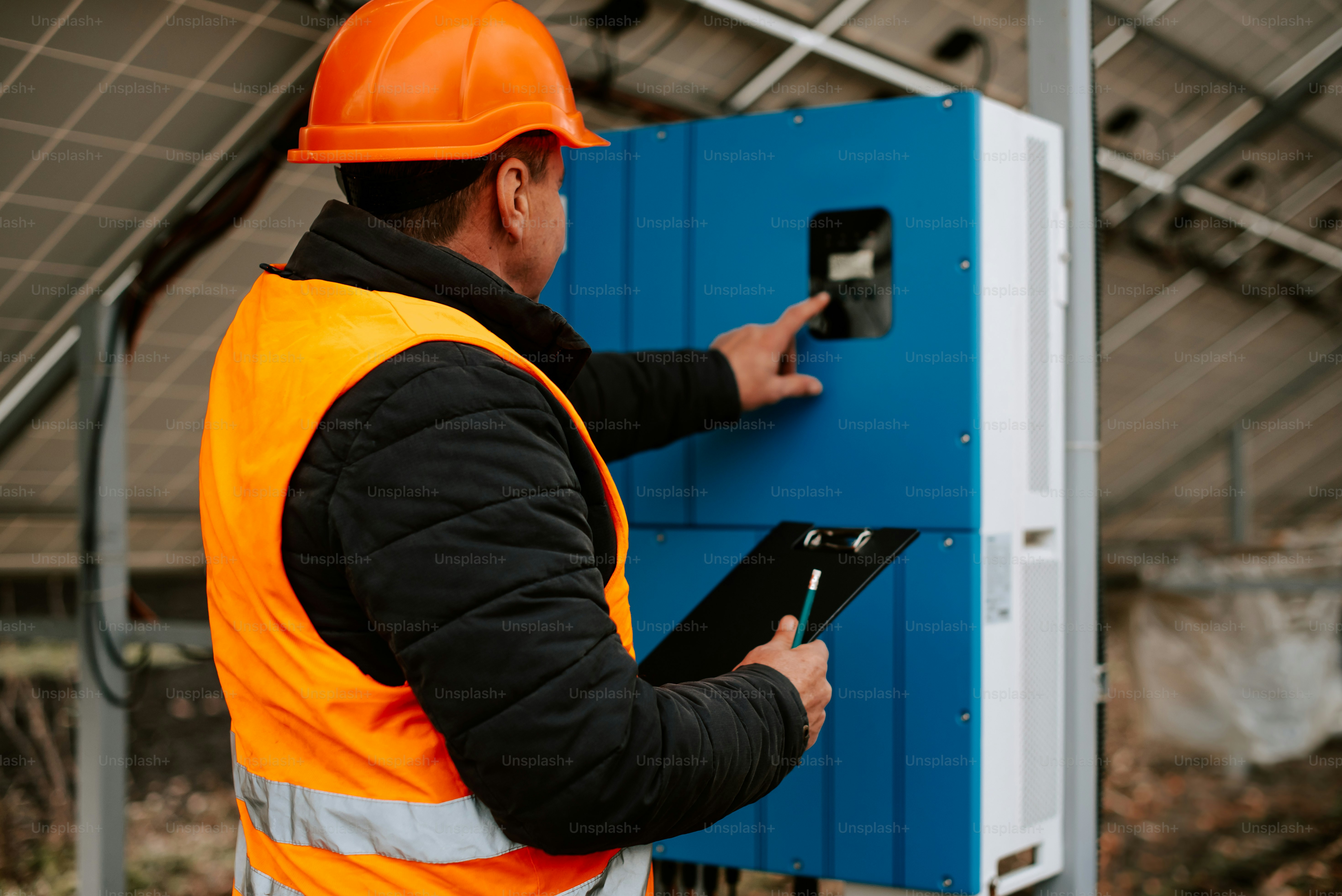 Ein Mann in orangefarbener Warnweste und Schutzhelm
