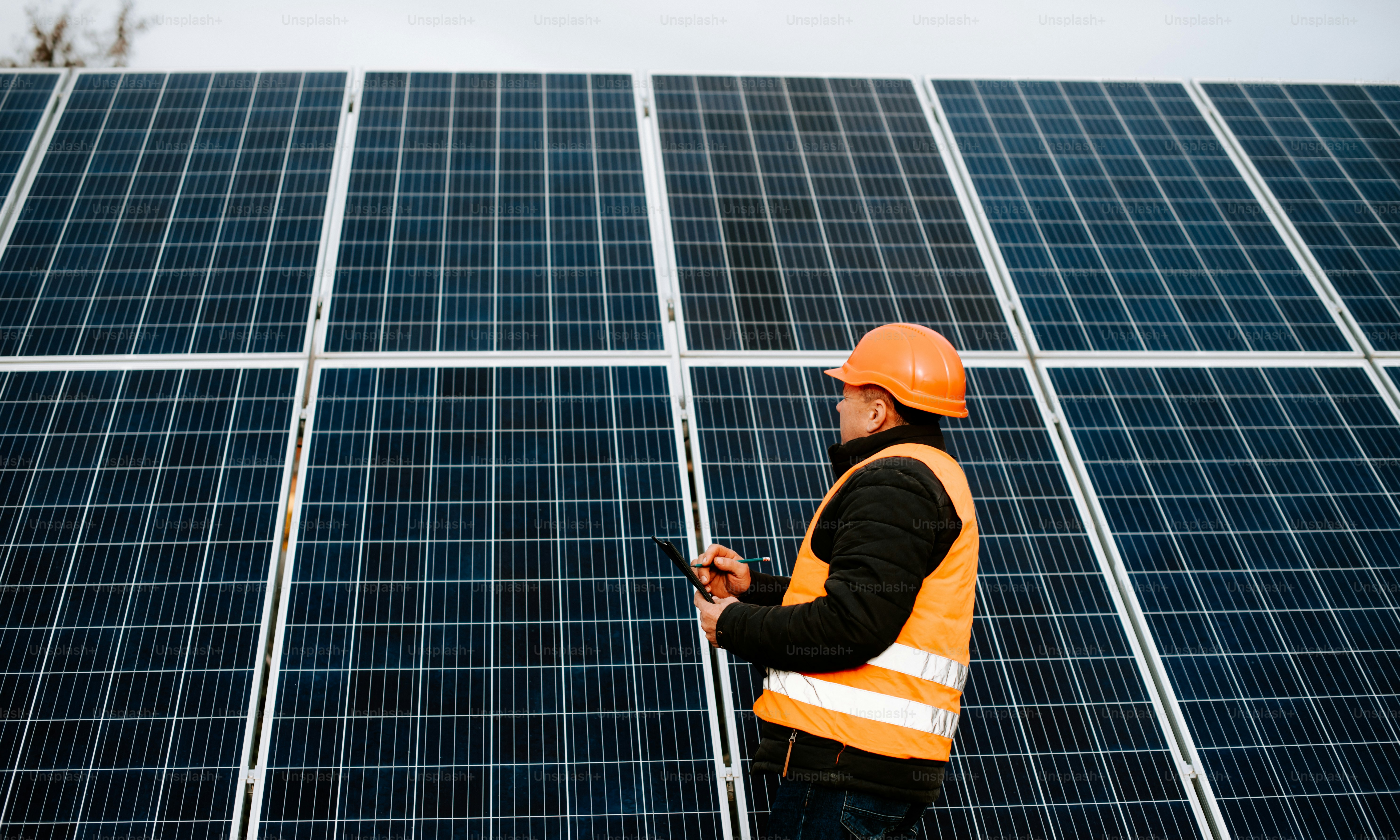 Ein Mann mit Schutzhelm vor einem Solarpanel
