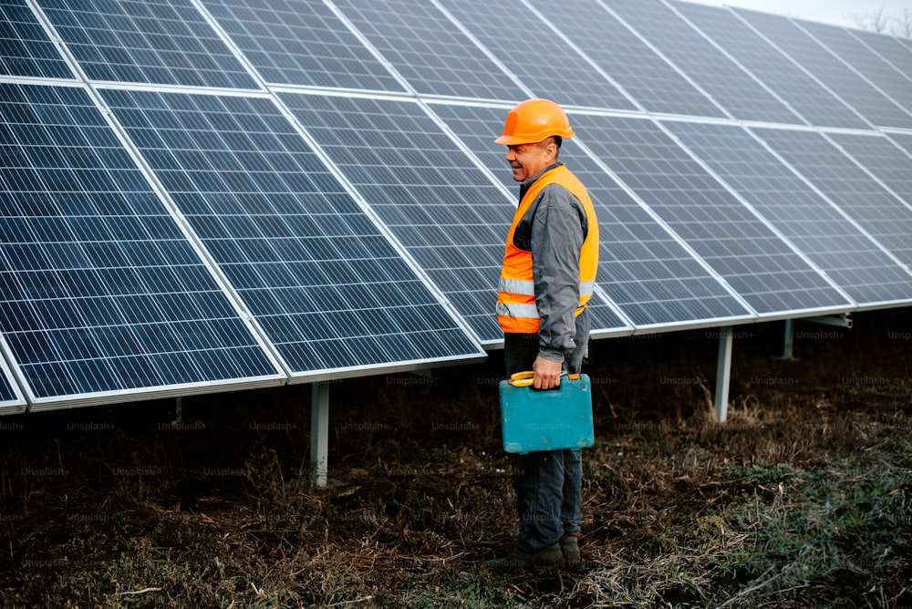 um homem de pé na frente de uma fileira de painéis solares