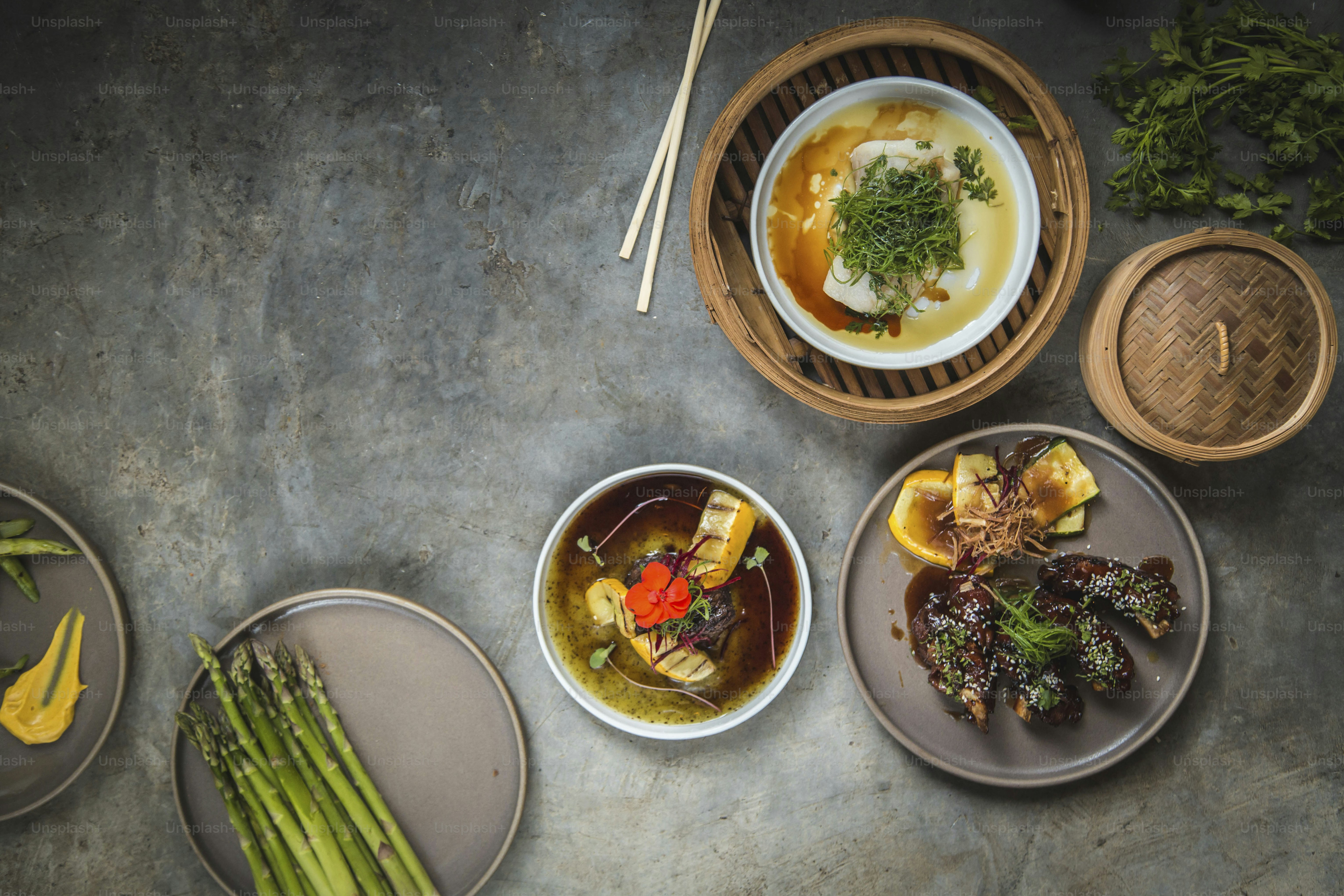 a table topped with plates of food and bowls of soup