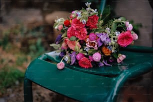 a bouquet of flowers sitting on top of a green chair