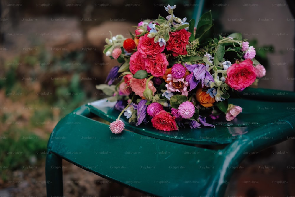 a bouquet of flowers sitting on top of a green chair