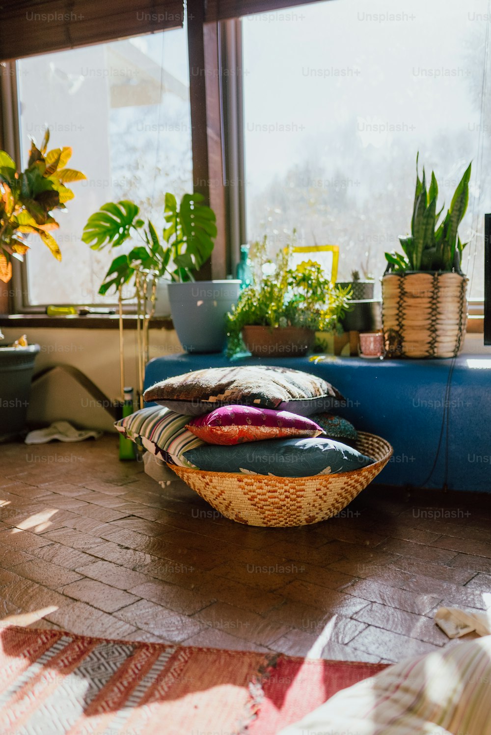 a basket filled with pillows sitting on top of a wooden floor