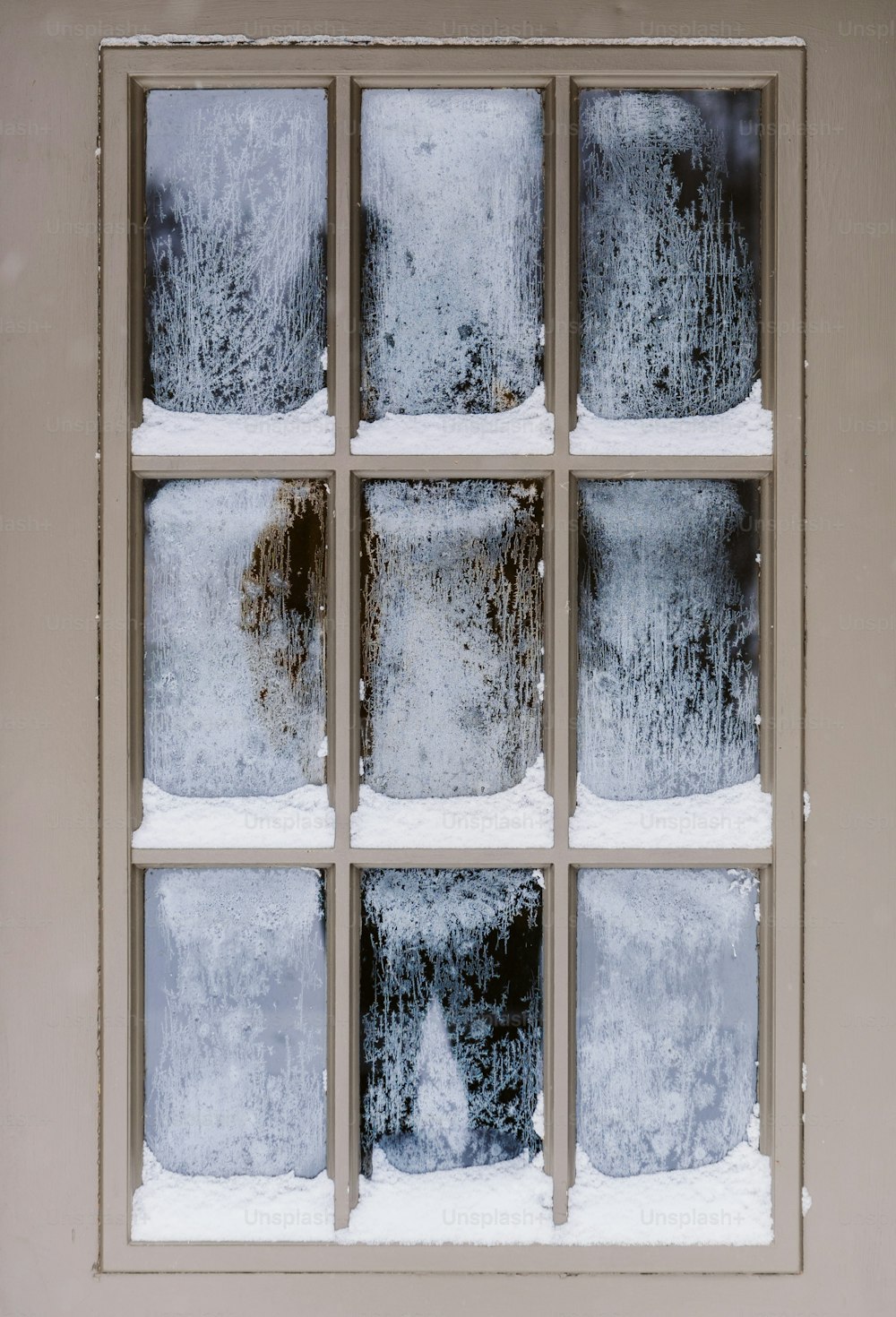 una finestra che ha la neve all'esterno di esso
