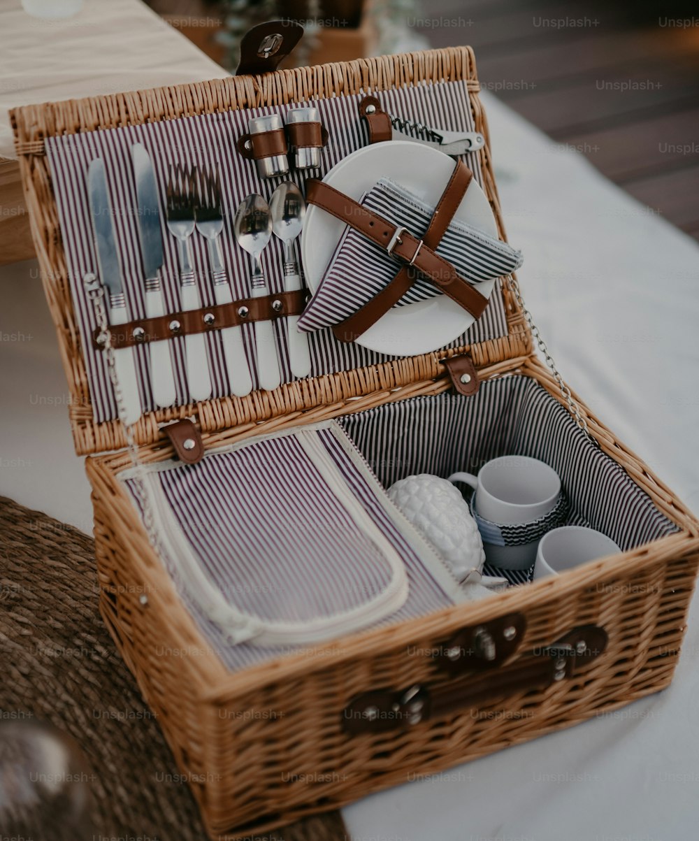 a wicker picnic basket filled with dishes and utensils