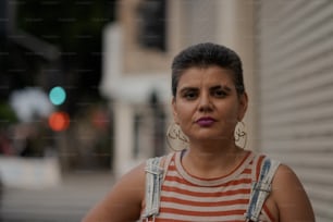 a woman in a striped shirt is standing on the street