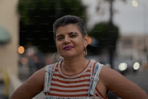 a woman wearing a striped shirt and overalls