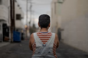 a woman walking down a street next to a building