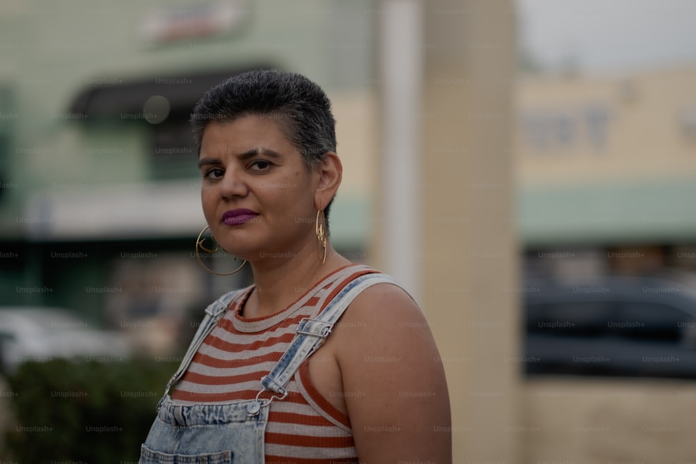 a woman wearing overalls and a striped shirt