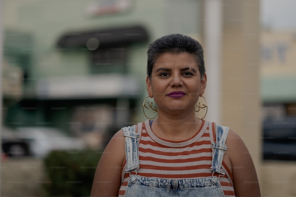 a woman in overalls and a striped shirt