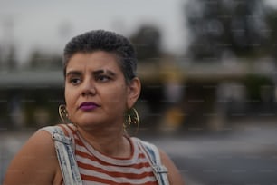 a woman with large hoop earrings and a striped shirt