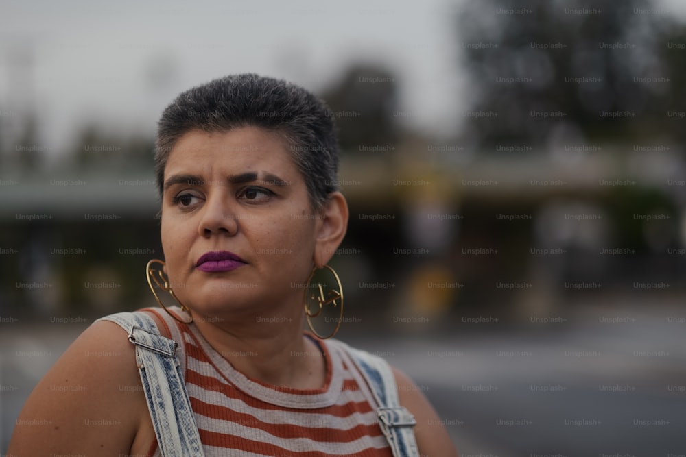 a woman with large hoop earrings and a striped shirt