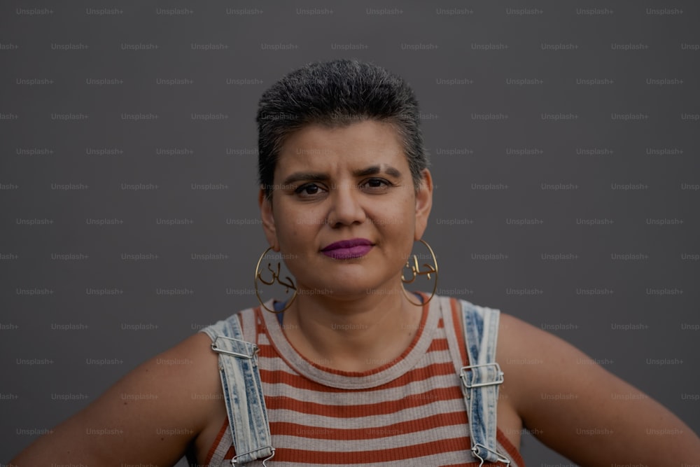 a woman wearing a striped shirt and a pair of earrings