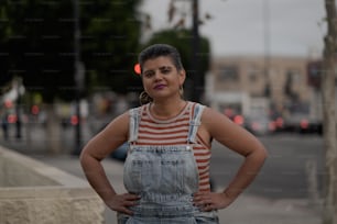 a woman standing on a sidewalk with her hands on her hips